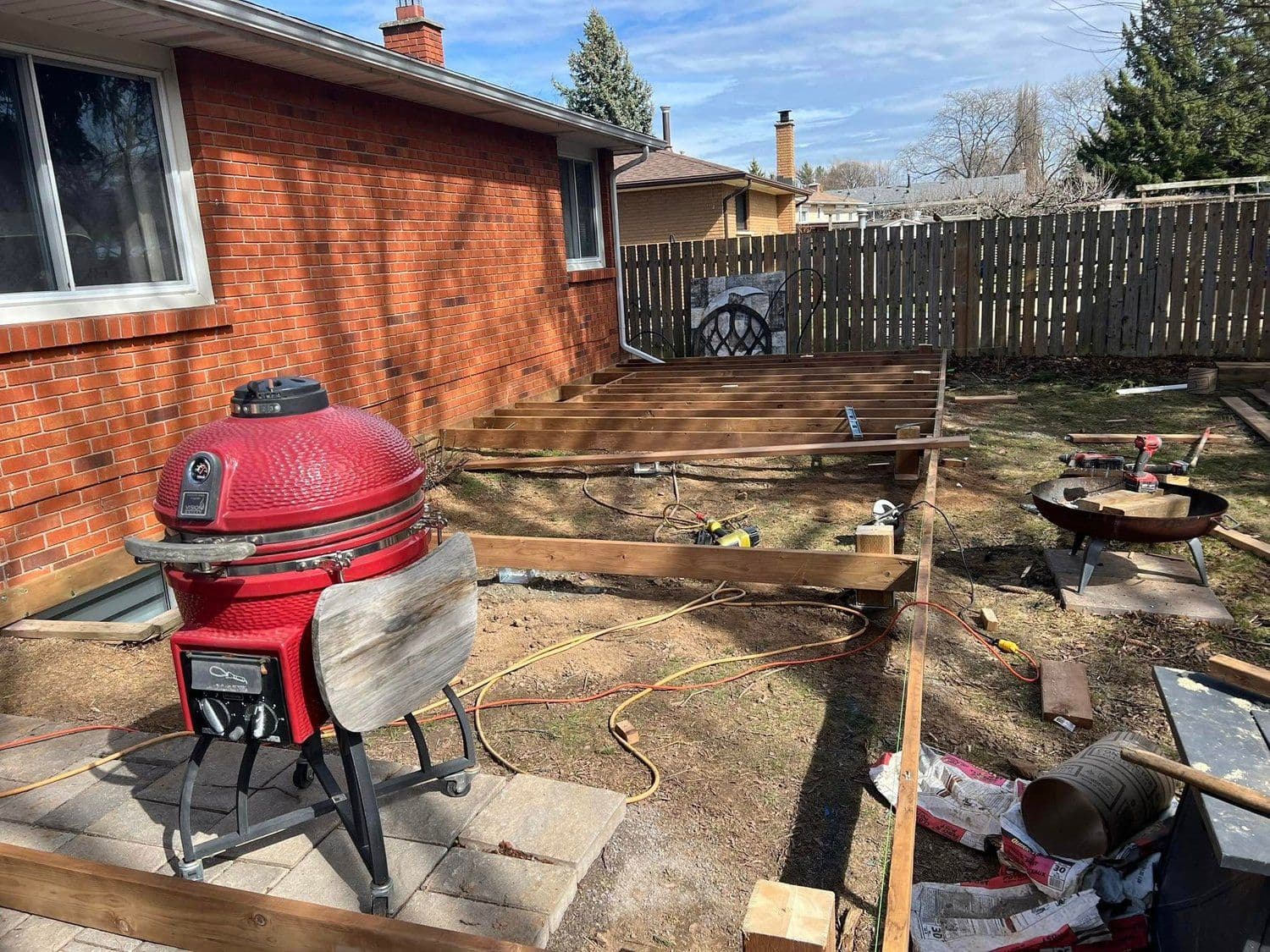 Backyard patio build in progress with grill and stained boards